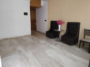 a waiting room with chairs and a table with a vase of flowers at Collection O Sun Park in Bhopal +28 photos