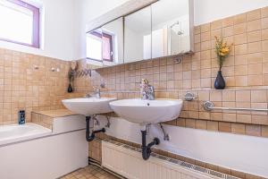 a bathroom with two sinks and a tub and a mirror at Cozy Central 11BR shared Stay with Garden Access & Terrace in Vienna +139 photos