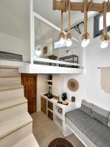 a living room with a staircase and a couch at Babatseratsi skyrian studio 1 in Skiros