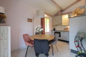 a kitchen with a wooden table and some chairs at Heidehuysje in Holten