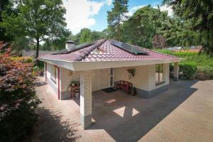 a small house with a roof on a patio at Heidehuysje in Holten