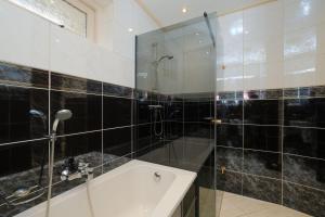 a bathroom with a shower and a sink at Heidehuysje in Holten +23 photos