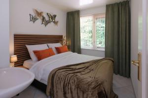 a bedroom with a bed and a tub and a sink at Heidehuysje in Holten