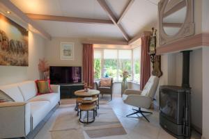 a living room with a white couch and a fireplace at Heidehuysje in Holten