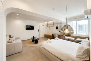 a bedroom with a large white bed and a couch at Megaro Luxury Suite 11 in Syntagma in Athens