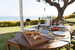 a wooden table with food and wine on it at Exclusive Mediterranean Panorama in Sant Pol de Mar in San Pol de Mar