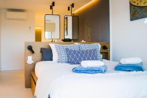 a bedroom with a large white bed with blue pillows at Exclusive Mediterranean Panorama in Sant Pol de Mar in San Pol de Mar +56 photos