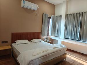 a bedroom with a bed and a air conditioner at Parin Hotel And Resort in Ratnagiri