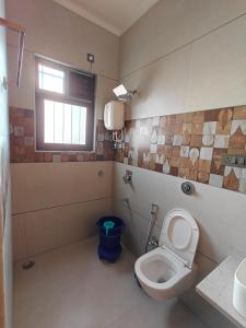 a bathroom with a toilet and a sink at Parin Hotel And Resort in Ratnagiri