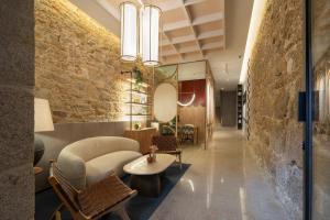 拉科鲁尼亚Marina 30的大堂设有石墙和桌椅