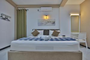 康提Kandy River Lodge的一间卧室配有一张带蓝白色床单的大床