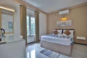 a bedroom with a king sized bed and a bathroom at Kandy River Lodge in Kandy