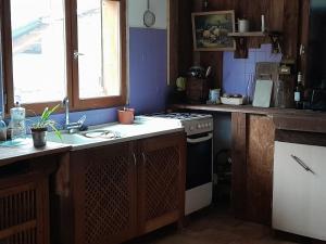 a small kitchen with a stove and a sink at Maison isolée tout équipée in La Piarre