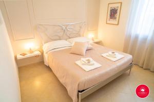 - une chambre avec un lit, 2 serviettes et 2 tables dans l'établissement Casa Rosa, à La Spezia