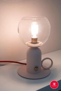 une lampe avec bougie dans un dôme de verre dans l'établissement Casa Rosa, à La Spezia