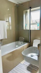 a bathroom with a tub and a sink and a shower at Hideaway Haven 2 in Cape Town +9 photos
