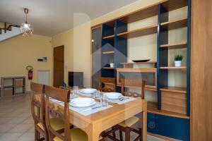 a dining room with a wooden table and chairs at Homiday - Palazzo Passerini in Pineto