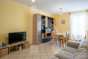 a living room with a couch and a tv and a table at Homiday - Palazzo Passerini in Pineto