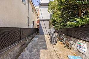 a bicycle parked next to a building with an umbrella at Snow Forest2 in Tokyo