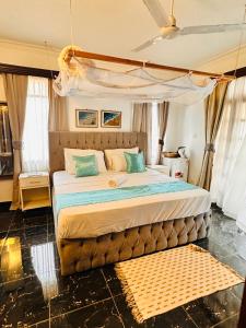 a bedroom with a large bed with a canopy at A private room in,Coastal Bliss homestsy in Mombasa +7 photos