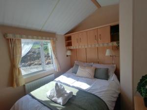 Seaside chalet in Ardmore with breathtaking views في أردمور: غرفة نوم صغيرة مع سرير مع نافذة