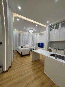 a kitchen and living room with a couch and a table at Our Home in Da Lat