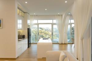 a living room with a white couch and a large window at Our Home in Da Lat