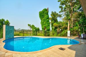 a swimming pool with blue water in a yard at Aveeno Resort & Villas Near Calangute and Baga in Jāmb