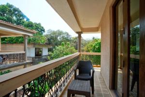a balcony with two chairs and a bench at Aveeno Resort & Villas Near Calangute and Baga in Jāmb