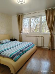 a bedroom with a bed and a large window at ARKA Apartment in Craiova