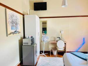 a bedroom with a bed and a desk with a fan at St Eve Lodge & Spa in Bloemfontein
