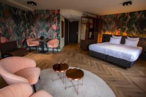 a hotel room with a bed and a table and chairs at Hotel Greenside Texel in De Koog