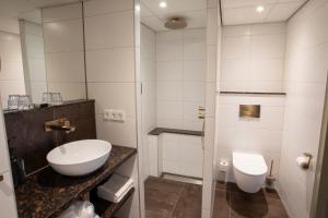 a bathroom with a sink and a toilet at Hotel Greenside Texel in De Koog +21 photos