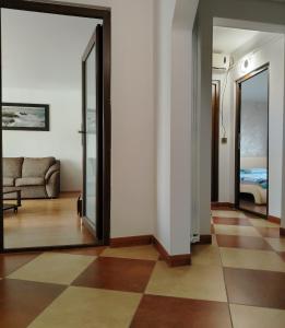 a living room with a couch and a mirror at ARKA Apartment in Craiova