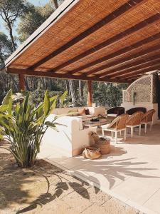 a patio with tables and chairs under a wooden roof at Villa Kalimera in Ginosa Marina +20 photos
