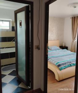 a mirror in front of a bedroom with a bed at ARKA Apartment in Craiova