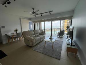 a living room with a couch and a table at Waterfront Getaway Darwin City in Darwin