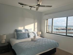 a bedroom with a bed with a view of the ocean at Waterfront Getaway Darwin City in Darwin