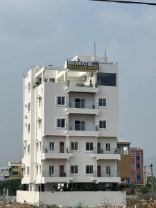 een wit gebouw met een bord erop bij BHARATHI STAYS Ultra luxury rooms 1RK Studio Apartments & 2BHK Apartments in Tirupati