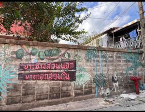 a wall with a painting of a dog on it at Papaya House Bangkok - Wat Arun in Bangkok Noi