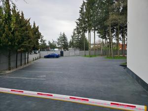 een parkeerplaats met een blauwe auto erin geparkeerd bij W64 Apartamenty in Płock