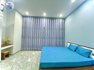 ダナンにあるHG Houseのベッドルーム(青いベッド1台、大きな窓付)