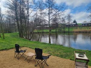 two chairs and a table next to a lake at Rybářský sen in Olbramkostel