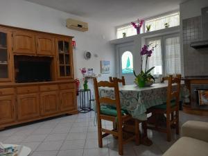 a kitchen with a table with chairs and a tv at Appartamento L'Orchidea in Forio d'Ischia