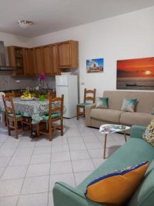 a kitchen and living room with a table and a couch at Appartamento L'Orchidea in Forio d'Ischia