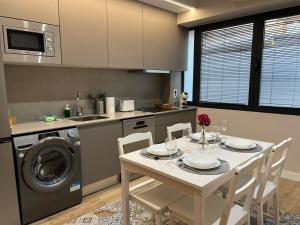 a kitchen with a table and a washing machine at Apartamentos Titus Decimus in Mérida