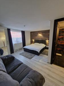 a large bedroom with a bed and a couch at Vila Karina in Teşila
