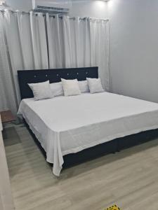 una camera da letto con un letto grande con lenzuola e cuscini bianchi di Diamonds Exclusive Resort a Diamond