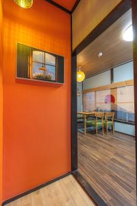 東京にある爵士猫东京一栋日式民宿のテーブル付きのダイニングルームのオレンジ色の壁