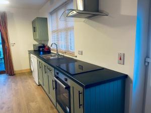 a kitchen with a black counter top and a sink at Brookhaven Lodge in Kilteely